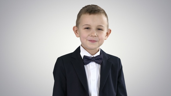 Smiling Little Boy in Formal Clothes Standing on Gradient