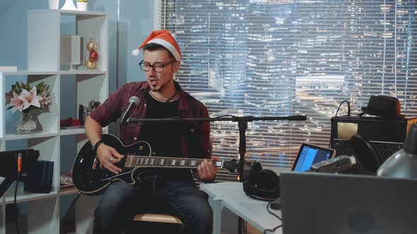 Home Recording Studio Young Vocalist in Santa Hat Singing Christmas Song Into Microphone and Playing