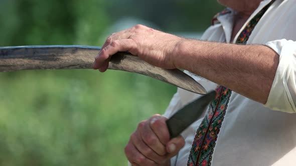 Man Sharpening His Scythe Close Up