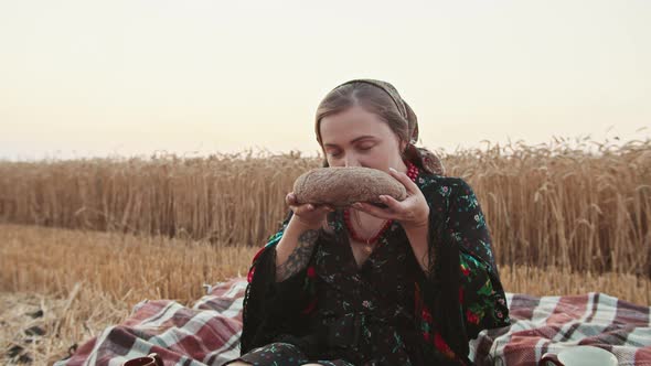 a Girl in a Wheat Field Breaks a Loaf of Bread and Sniffs the Smell of Bread