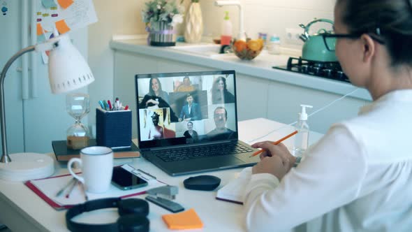 Woman Talks To Her Colleagues Via Laptop While Staying Home.