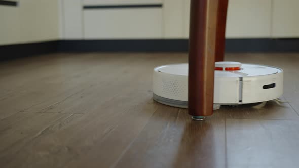 Robot Vacuum Cleaner Moving Around Table Legs