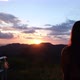 Silhouette rear view of a woman watching sunset sky on the mountain peak - VideoHive Item for Sale