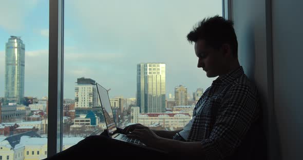 Purposeful Man Works Against the Background of Modern Buildings