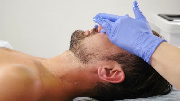 Wellbeing, Healthcare Concept. Man Lying on Couch at Beauty Clinic Getting Facial Treatment