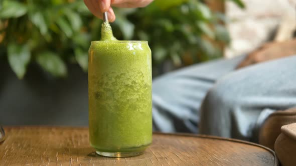 Woman Hand Takes Metal Straw and Stirs Vegetable Cocktail