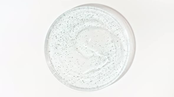 Rotation of Transparent Blue Cosmetic Gel Fluid with Bubbles in a Glass Bowl of Petri