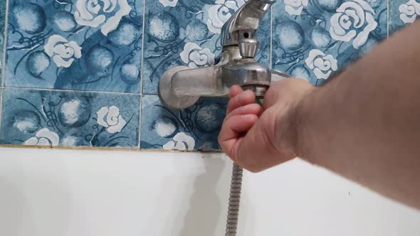 The Plumber Installs the Aerator in the Water Tap in the Bathroom