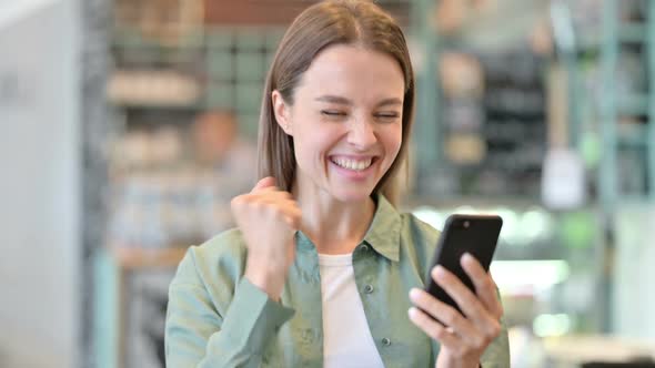 Portrait of Excited Woman Celebrating Success on Smartphone