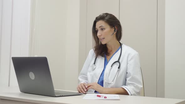 Female Doctor Wear Headset Make Online Video Call Consult Patient