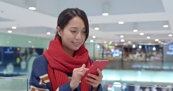 Woman work on cellphone in shopping center