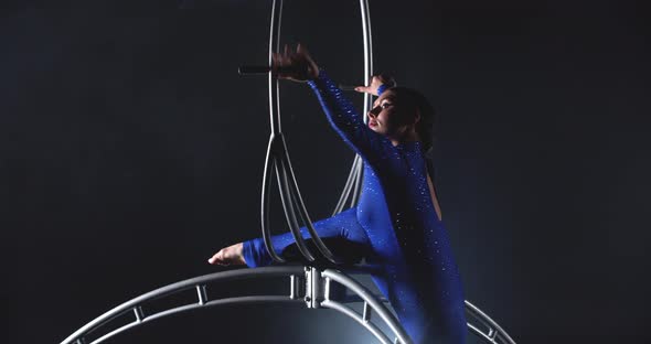 Gymnastics Show in a Spinning Hoop Woman in Blue Costume Doing a Split