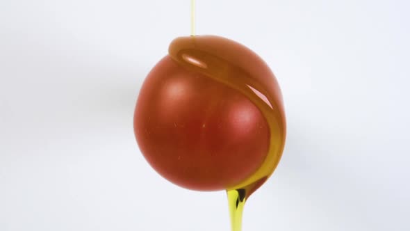 Splash of vegetable oil on a fresh cherry tomato