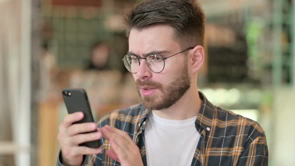 Portrait of Upset Young Man Having Loss on Smartphone