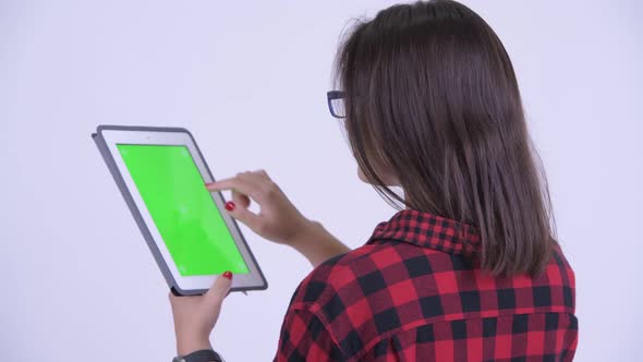 Rear View of Young Hipster Woman Using Digital Tablet