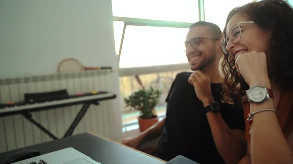 Happy couple having video conversation on laptop at home