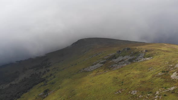 Aerial shot om mountains top covering by cloud 4K