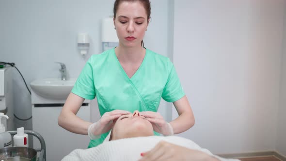 Female Beautician Makes Face Rejuvenation and Cleansing Procedure for Girl