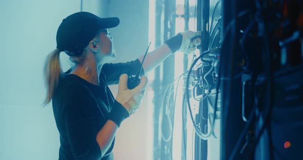 Female Employee with Walkie Talkie Checking Broken LED Screen