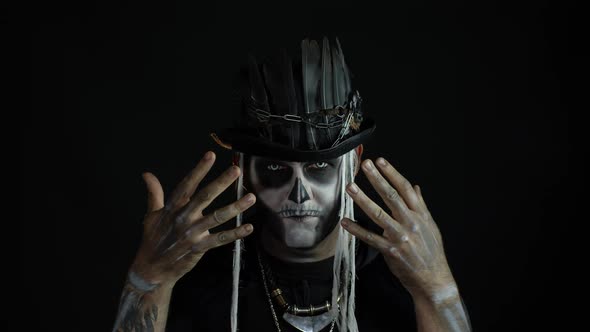 Scary Guy in Carnival Costume of Halloween Skeleton Against Black Background. Man Skull Makeup