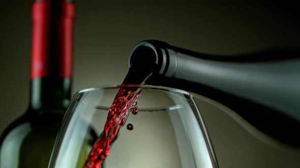 Super Slow Motion Detail Shot of Pouring Red Wine From Bottle on Luxury Grey Background at 1000Fps