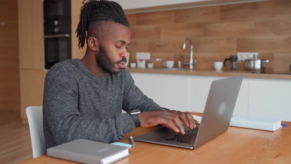 Concentrated African American Male Freelancer Working Online on Laptop at Home