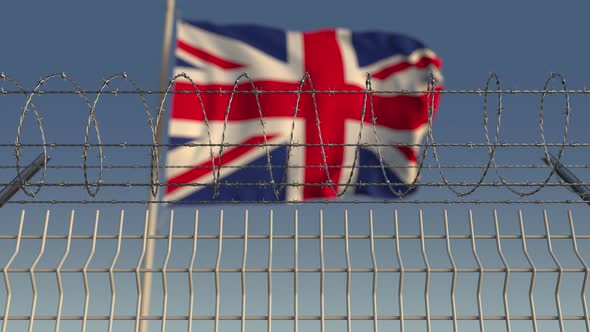 Defocused Waving Flag of the UK Behind Barbed Wire