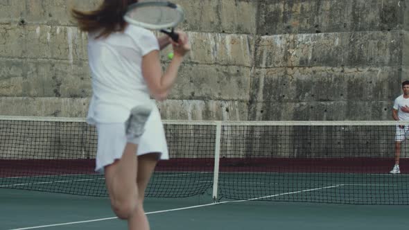 Woman and man playing tennis on a court