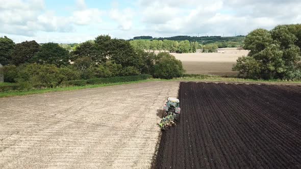 Aerial footage over tractor ploughing field