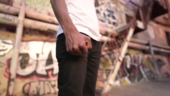 Close-up of a black guy's fist on the background of a street with graffiti