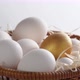 Close-up of a basket with white and golden chicken eggs. - VideoHive Item for Sale