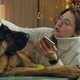 Young Woman Spend Christmas Holidays at Home with Her Pet on the Bed with Phone - VideoHive Item for Sale
