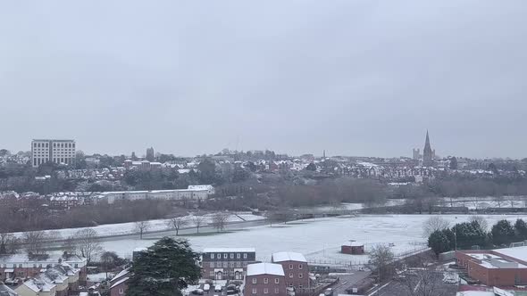 Tracking drone shot of snowy Exeter subburbs looking towards the town centre CROP