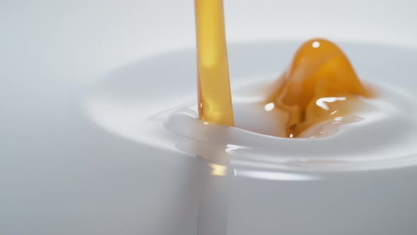 Pouring oil into milk and making splash. Slow Motion.