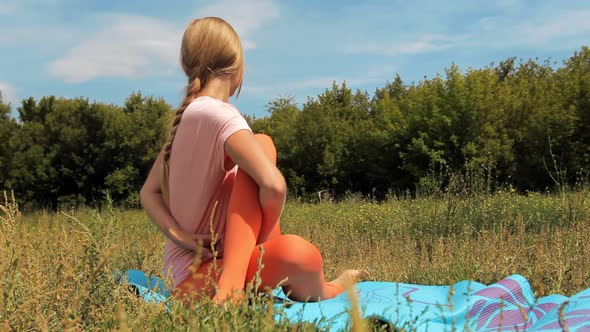 Adult Cute Girl Doing Yoga in the Park Outdoors on a Sunny Summer Day