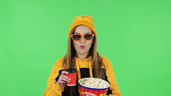 Portrait Girl in Yellow Hat in 3D Glasses Is Watching Movie, Eating Popcorn and Drinking Tasteless