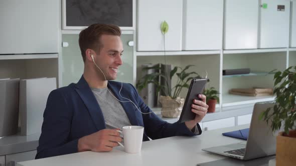 Handsome Businessman Using App on the Touch Screen Tablet for Video Call