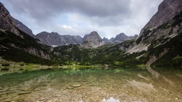 Time Lapse Clouds and Sunrays Move over Mountain Lake in Austrian Alps