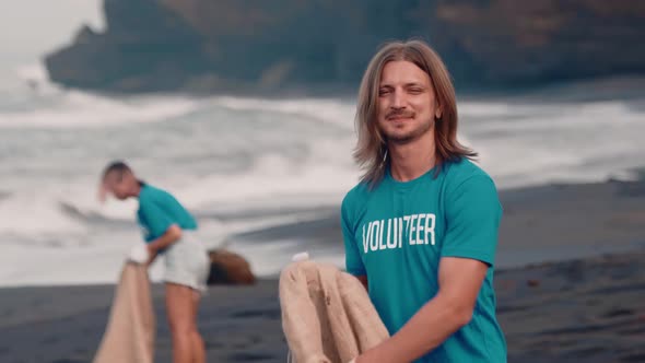 Volunteer Puts Plastic Bottle in an Eco Bag Puts Into Making Planet Better