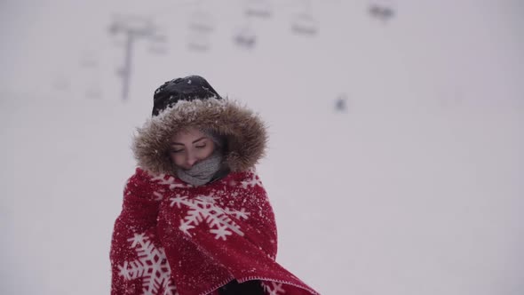 Close Up of Frozen Woman Wrapped in a Blanket at Snowstorm