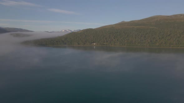 Lake Sjodalsvatnet On A Misty Morning With Forest Mountains In Jotunheimen National Park, Vaga, Norw