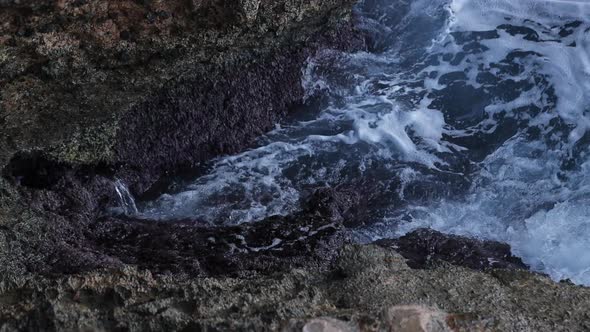 Waves crashing against sea cliff. Detail shot in slow motion of the foam