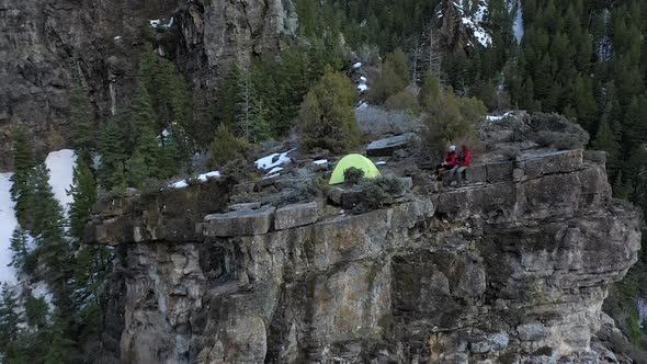 Flying towards tent on top of a cliff looking down at the campsite