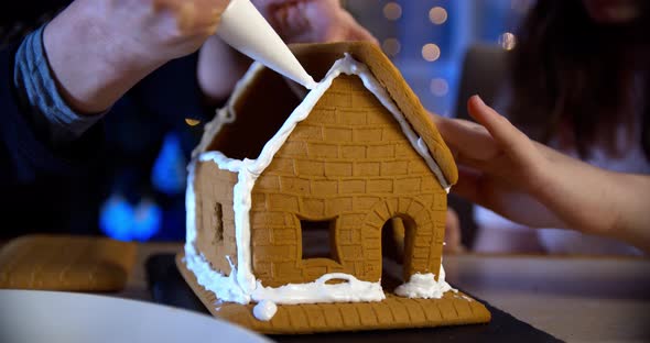Woman Decorate Gingerbread House