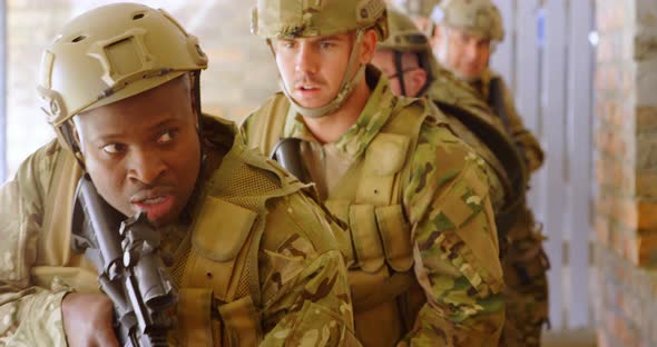 Front view of mixed-race military soldiers walking with rifles during military training 4k