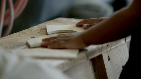 Young girl playing with wood pieces in the wood shop.