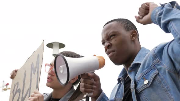 Protest Against Racism. Girl with Glasses Waving a BLM Banner. Together with the Black Guy They Are