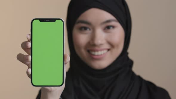 Portrait Asian Girl Muslim Islamic Woman in Black Hijab Smiling Showing Mobile Phone with Green