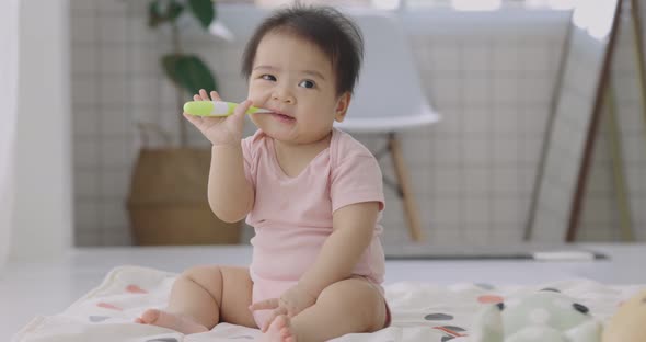 Adorable Asian Baby Practice To Using Toothbrush For Clean Her Oral For Good Oral Health.