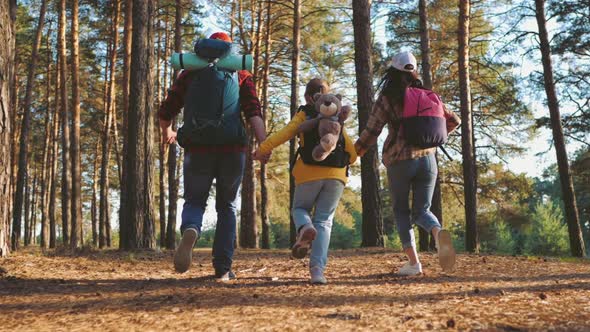 Happy Family Hiking Through a Forest